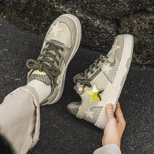 Person wearing green sneakers with star designs on a dark surface