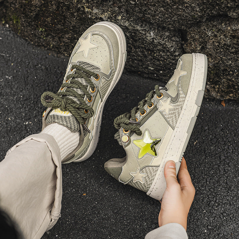 Person wearing green sneakers with star designs on a dark surface